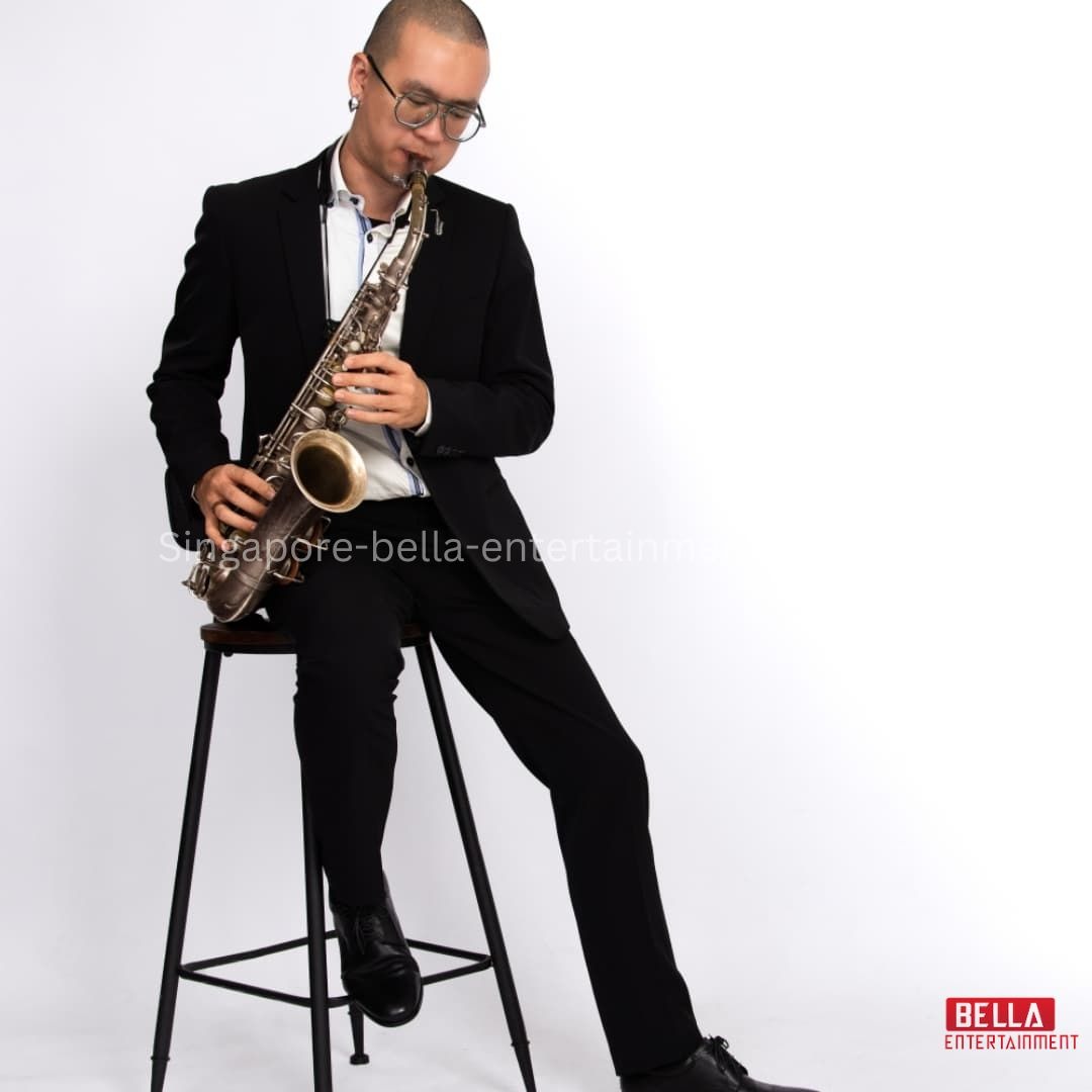 Man in a black suit sitting on a stool playing a saxophone, Saxophonist