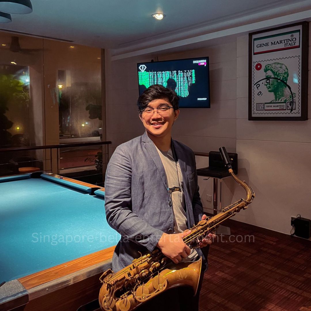 Man standing in front of a pool table, holding a saxophone, Saxophonist