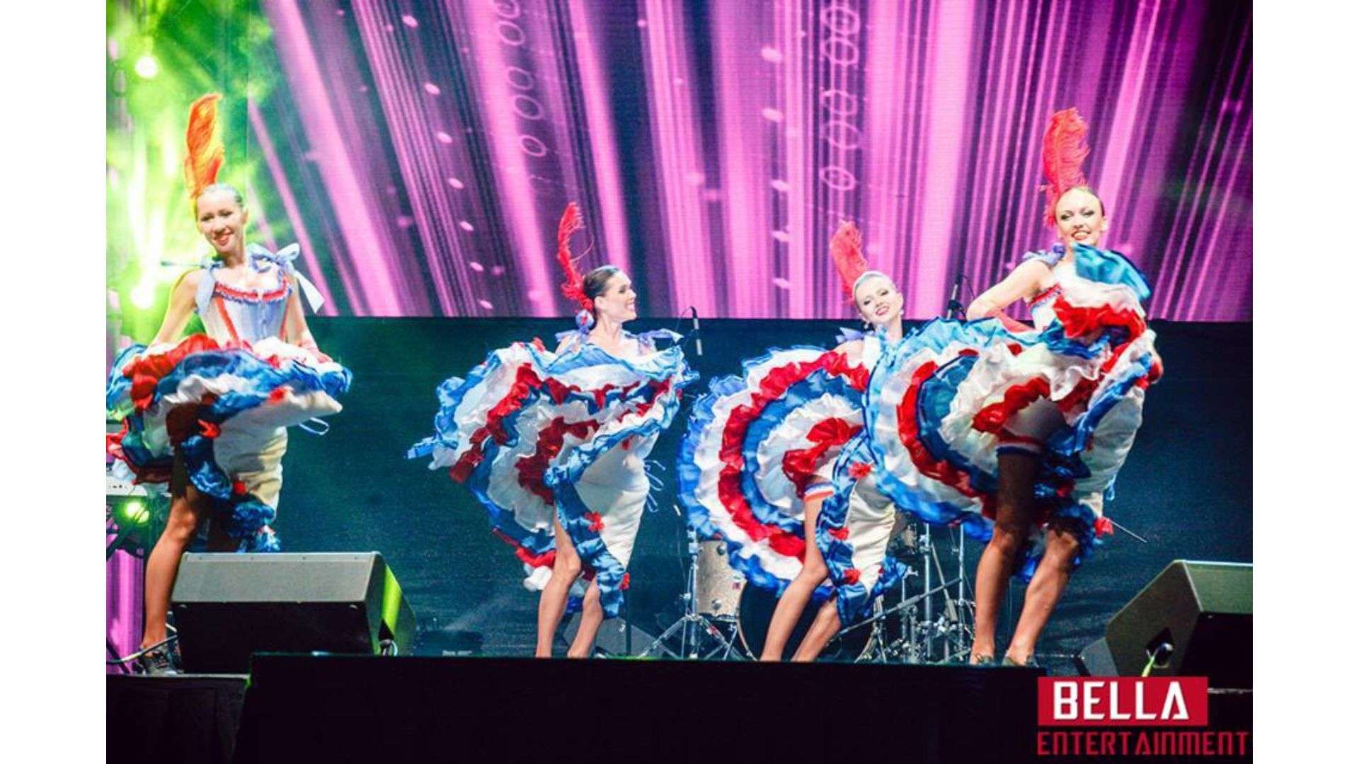 Group of women in colorful dresses dancing on a stage, surrounded by musical instruments, mics with stands,, Flamenco Dancer for Hire