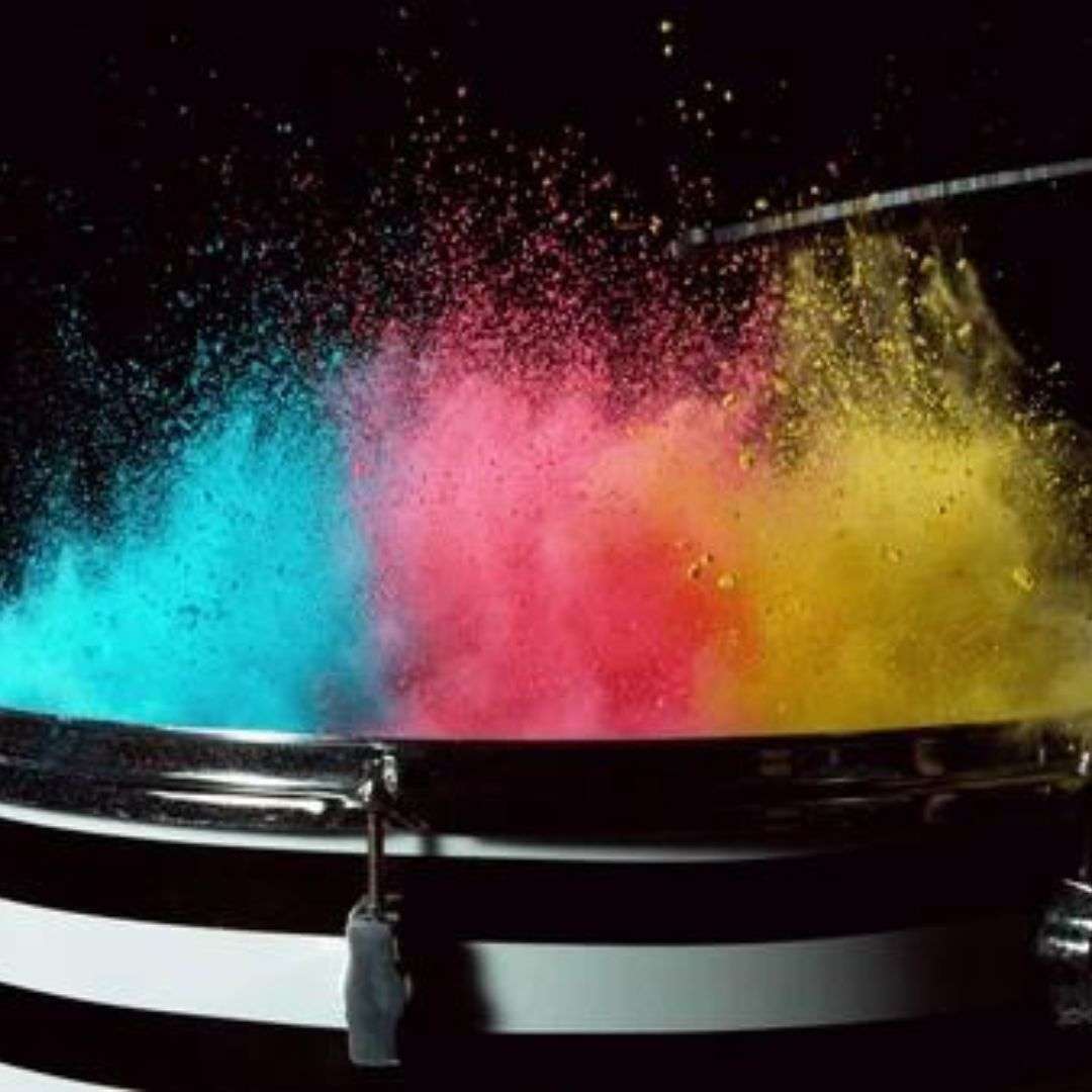 Drum with colorful powder exploding out of it against a dark background, creating a vibrant and dynamic, LED Water Drummer for Hire