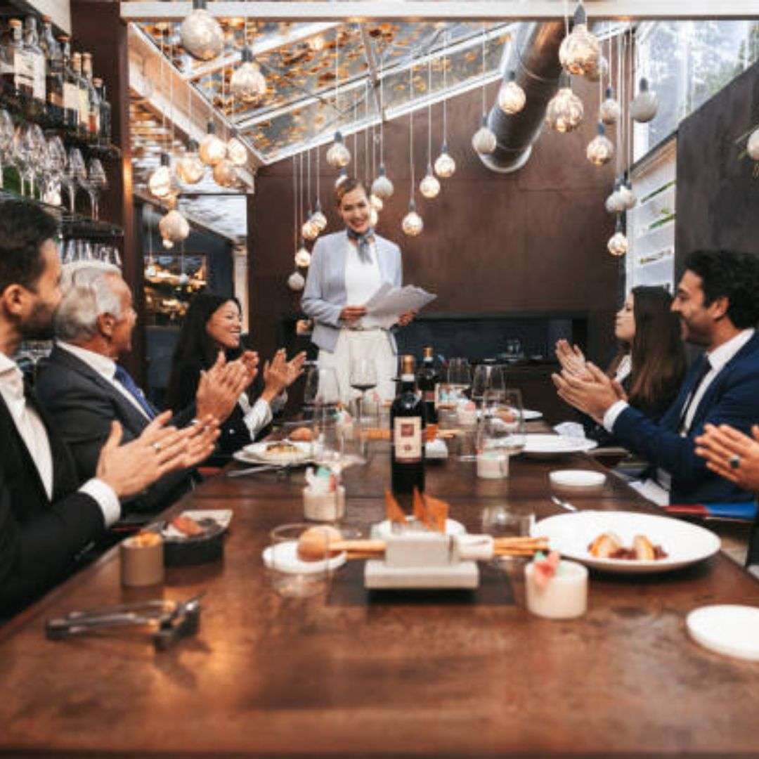 Group of people sitting around a table in a restaurant, clapping their hands in appreciation, Hire Corporate D&D in Singapore