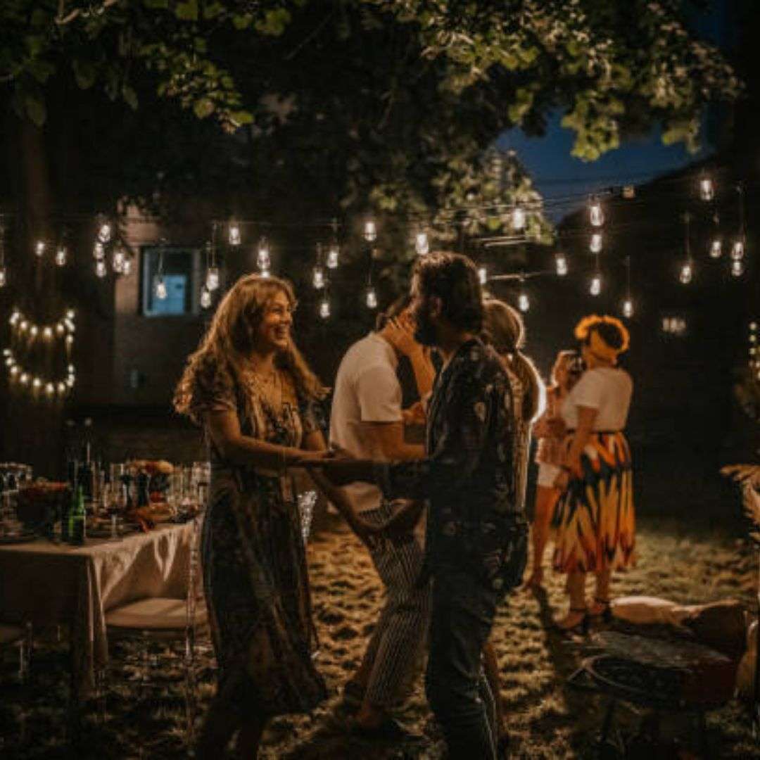 Group of people dancing under string lights at night, Hire Corporate D&D in Singapore