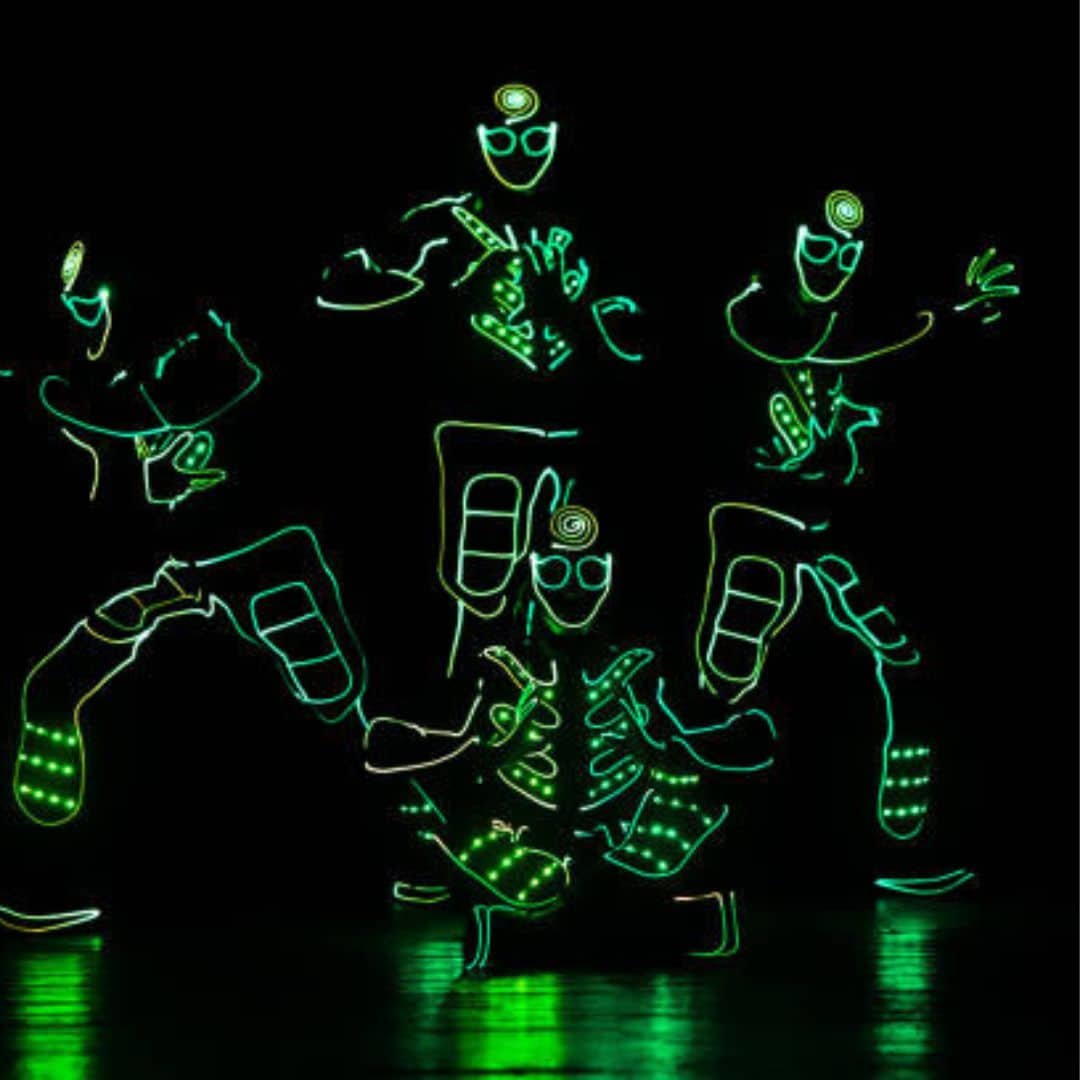 Green LED robot dancers on a dark stage in Singapore